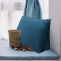 Auf einer gemütlich arrangierten Fensterbank liegt ein marineblaues Keilkissen – perfekt zum Lesen.