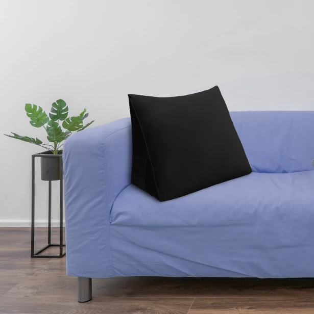 Schwarzes Rückenstützkissen, arrangiert im Wohnzimmer auf dem Sofa.