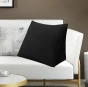 Schwarzes Rückenstützkissen, arrangiert im Wohnzimmer auf dem Sofa.