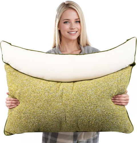 Eine lächelnde junge Frau hält ein großes, ergonomisches grünes Schlafkissen.