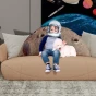 Ein Kind mit Astronautenhelm und ein weißer Hund sitzen auf einem beigen Sofa mit einem riesigen 3D-Mondkissen.