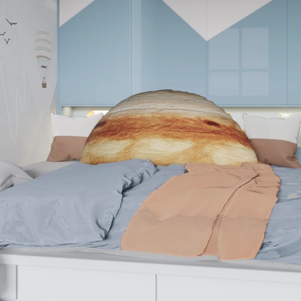 Großes Dekokissen mit 3D-Jupiter-Motiv auf einem weißen Bett.