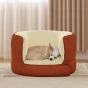 Der entzückende kleine Hund schläft zusammengerollt in einem außergewöhnlich weichen und bequemen erhöhten Bett in einem warmen Terrakotta-Beige-Ton.