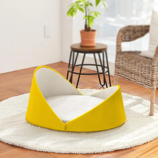 Luxuriöses Muschel-Katzenbett – gelb, in einem hellen, stilvollen Interieur.