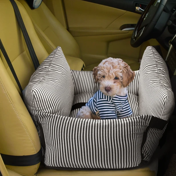 2-in-1-Autositz mit All-Terrain-Bett. Ein entzückender Welpe in einem gestreiften T-Shirt sitzt in einem Hunde-Autositz.