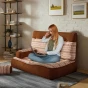 Frau arbeitet an einem modularen Sofa, einem Bodensofa im Boho-Stil.