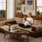 Schwangere Frau ruht sich auf einem modularen Sofa aus, einem Bodensofa im Boho-Stil.