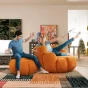 Ein junges Paar sitzt auf kürbisförmigen Poufs.