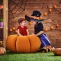 Kinder spielen auf einem kürbisförmigen Pouf.