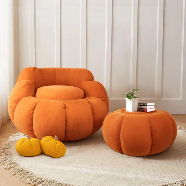 Zwei mit luxuriösem Samt bezogene Poufs in Form eines Kürbisses.