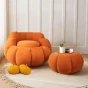 Zwei mit luxuriösem Samt bezogene Poufs in Form eines Kürbisses.