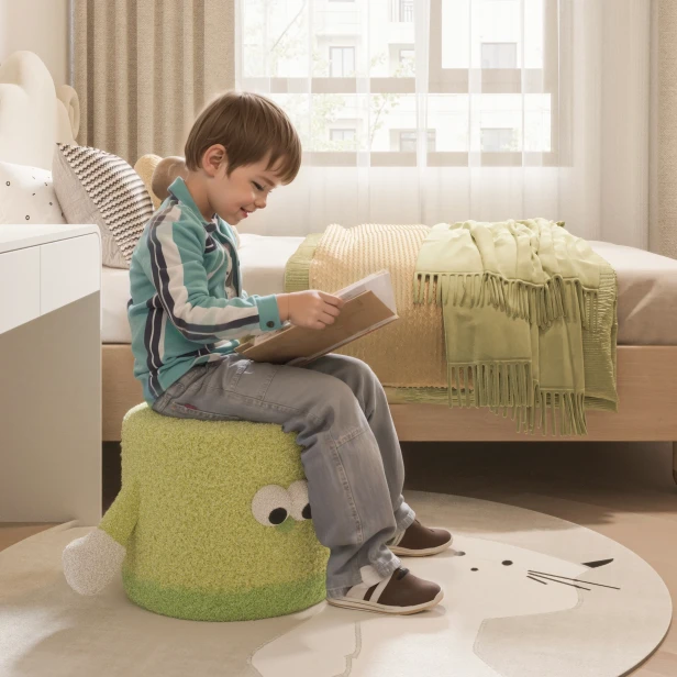 Ein Junge sitzt lesend auf dem Sitzkissen „JoyPouch“ in einem Kinderzimmer.