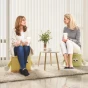 Zwei Frauen sitzen und unterhalten sich auf „JoyPouch“-Poufs, Wohnzimmerarrangement.