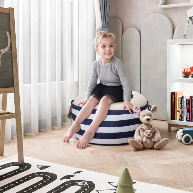 Mädchen sitzt auf einem Pouf mit einem Behälter (Aufbewahrung), Anordnung in einem Kinderzimmer.