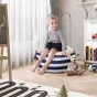 Mädchen sitzt auf einem Pouf mit einem Behälter (Aufbewahrung), Anordnung in einem Kinderzimmer.