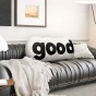 Plüschiges schwarzes Lesekissen. Arrangiert im Wohnzimmer auf dem Sofa.