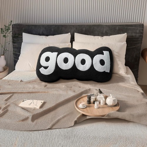 Plüschiges schwarzes Lesekissen. Schlafzimmer-Arrangement auf dem Bett.