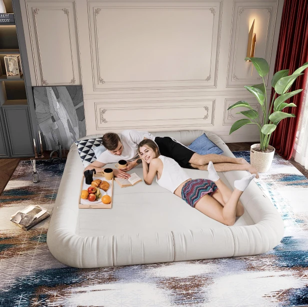Ein junges Paar liegt auf einem Schlafsofa, das im Wohnzimmer aufgestellt ist.