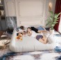 Ein junges Paar liegt auf einem Schlafsofa, das im Wohnzimmer aufgestellt ist.