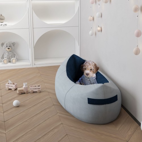 Welpe sitzt mit fröhlichem Gesicht im Bett im Kinderzimmer