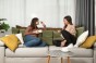 Frauen lehnen an einem Sofa mit einer grün-orangefarbenen Kopfstütze mit Stauraumkissen.