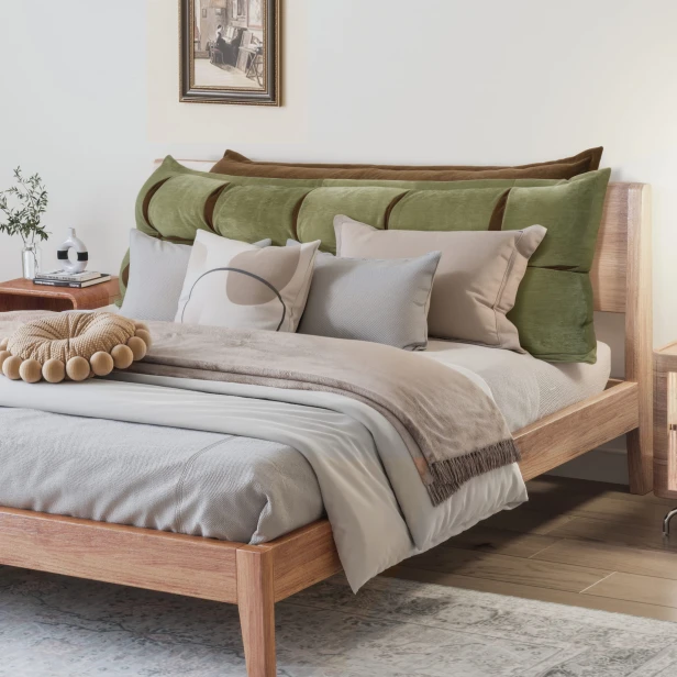 Grünes und oranges Kopfstützkissen mit Stauraum, Schlafzimmer-Arrangement auf dem Bett.