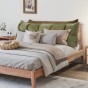 Grünes und oranges Kopfstützkissen mit Stauraum, Schlafzimmer-Arrangement auf dem Bett.