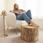 Eine Frau, die ihre Beine auf dem ovalen Hocker „Warm Tree Geometric“ ausruht.