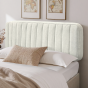 Beige gepolstertes Kopfteil, Schlafzimmeranordnung auf dem Bett.