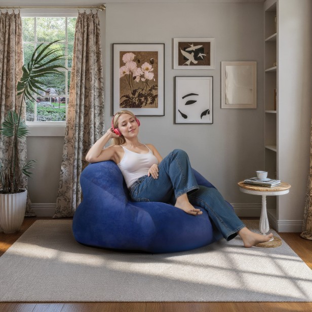 Blauer Pouf/Sessel, Frau sitzt in einem Sessel im Wohnzimmer.