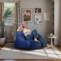 Blauer Pouf/Sessel, Frau sitzt in einem Sessel im Wohnzimmer.