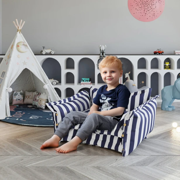 Junge sitzt auf einem Multifunktionssofa mit Bodenkissen im Kinderzimmer.