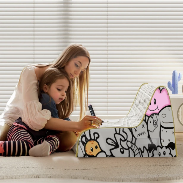 Frau mit Mädchen malt weiches Graffiti-Sofa für Kinder