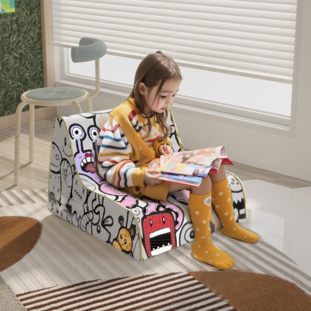 Mädchen liest Zeitung auf einem weichen Graffiti-Sofa für Kinder