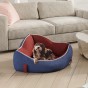 Ein Hund liegt in einem Eck-Hundebett