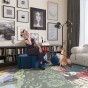 Frau sitzt im Wohnzimmer auf einem modernen blauen Pouf.