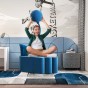 Junge sitzt und spielt Fußball auf einem modernen blauen Pouf.