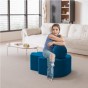 Frau sitzt im Wohnzimmer auf einem modernen blauen Pouf.
