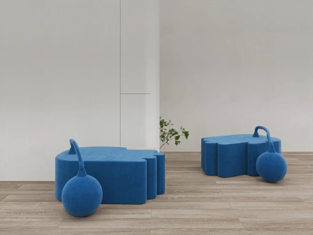 Moderner blauer Pouf, arrangiert im Wohnzimmer.
