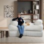 Ein Mann sitzt mit einer Katze auf einem Sofa mit weicher Entspannungszone.