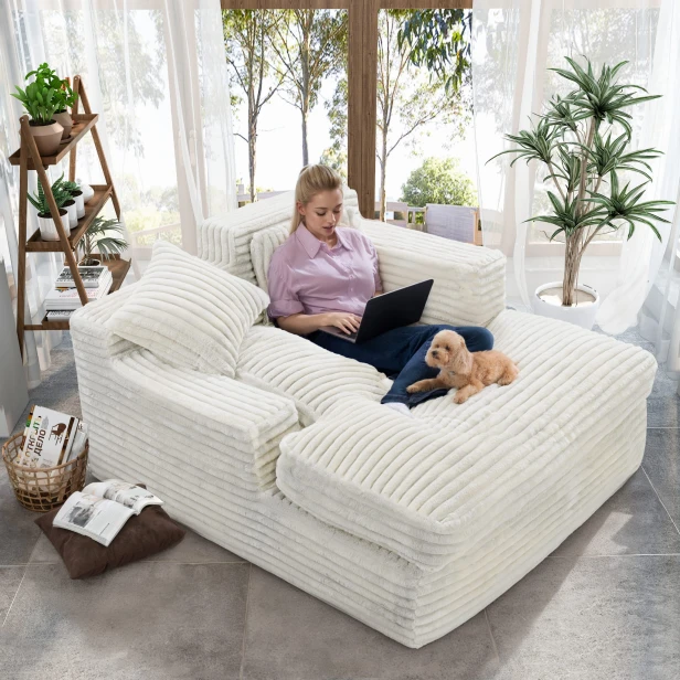 Eine Frau sitzt mit ihrem Hund auf einem weichen Sofa im Wohnzimmer.