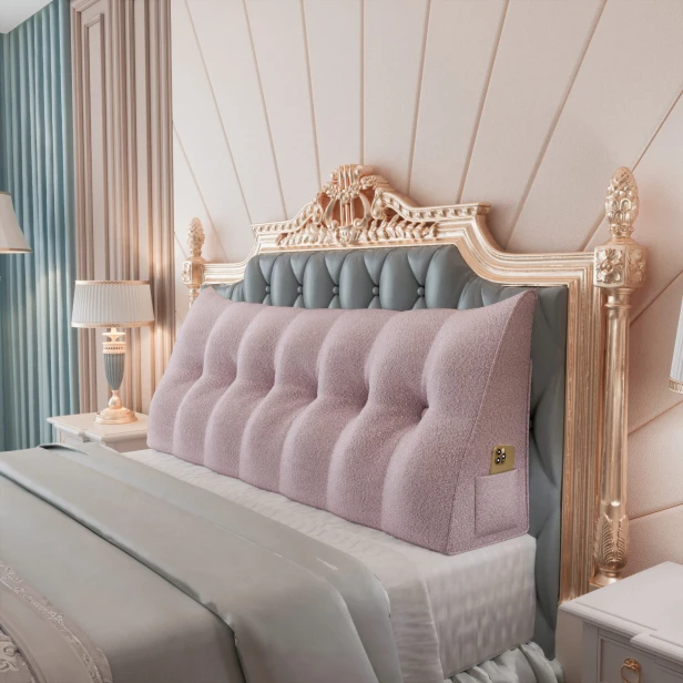 Dreieckiges, plüschiges, rosafarbenes Kissen, arrangiert im Schlafzimmer auf dem Bett.