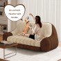 Frau sitzt mit Hund auf dem Comfort-Sofa, Wohnzimmer-Arrangement.
