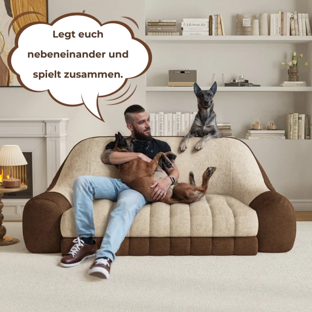Ein Mann sitzt mit zwei Hunden auf einem Sofa.