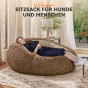 Frau liegt entspannt auf einem Sitzkissen.