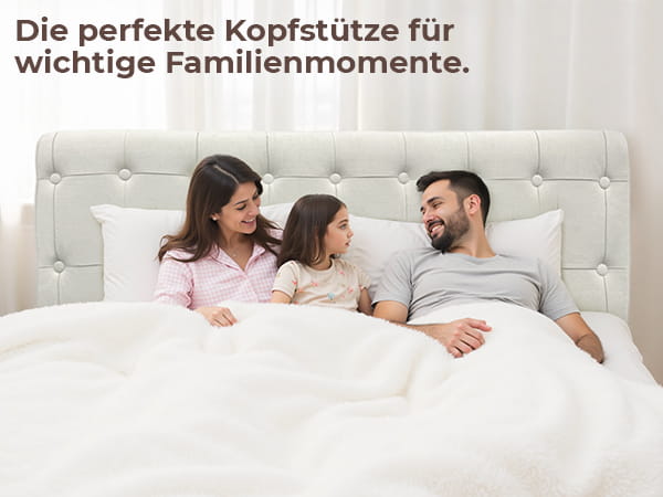 Glückliche dreiköpfige Familie im Bett mit dem gesteppten Knopfkopfteil