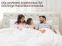Glückliche dreiköpfige Familie im Bett mit dem gesteppten Knopfkopfteil