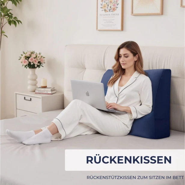 Eine Frau lehnt sich an ein Bett und ein marineblaues Multifunktions-Sofakissen.