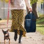 Frau mit Hund trägt ein tragbares Reisebett für Haustiere