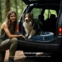 Hund im Auto mit einer Frau auf einem tragbaren Reise-Haustierbett
